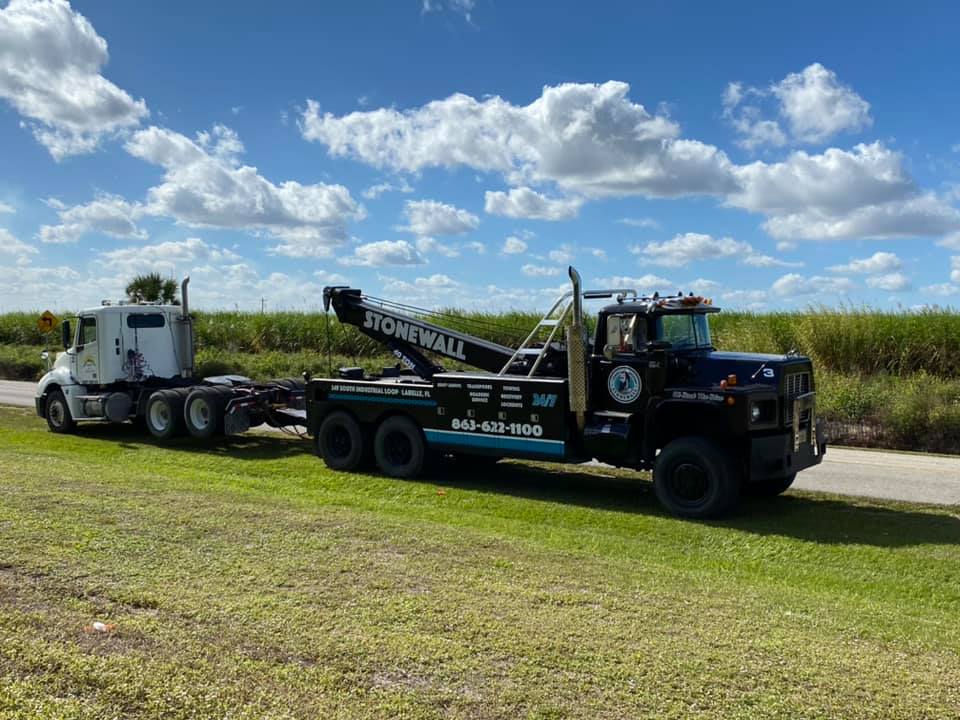 Stone Wall tow truck with a semi truck, without trailer, in tow.